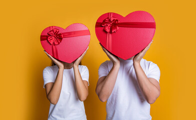 Couple with heart. Happy valentines day. Couple in love. Love romantic gift. Sweetheart. Family couple with valentines present. Gift of heart. Man and woman isolated on yellow. 14 February