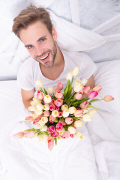photo of young man with womens day flowers bouquet. man with womens day flowers.