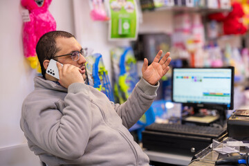 man making phone call on cashier table in dolls store