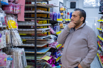 Male selecting school supplies for his kids in school supplies store