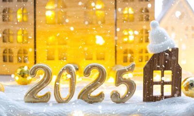 Golden figures number 2025 and tiny home on background of cozy windows of a house with warm light...