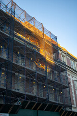 scaffolding adorns a city building during sunset. brooklyn construction