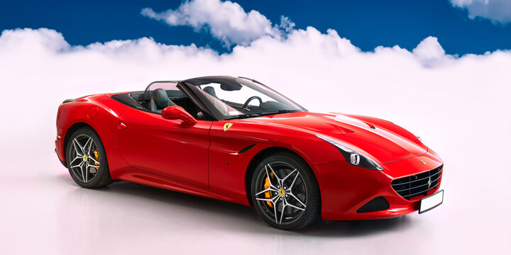 Red Ferrari California T. Cabriolet with V8 BiTurbo engine, 3.9L, 560 hp. Studio photography, against the background of clouds. Katowice, Poland - 04.13.2019