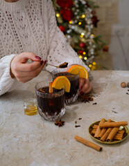 Young Woman holding glass of hot mulled wine. Homemade hot spicy wine.
