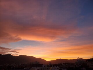 Warm sunset view on the horizon behind the mountains in the city