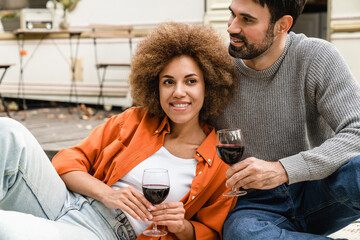 Cheerful loving couple husband and wife spending time together on celebration with red wine, traveling together by camper van motor wheel home trailer, having romantic picnic - Powered by Adobe