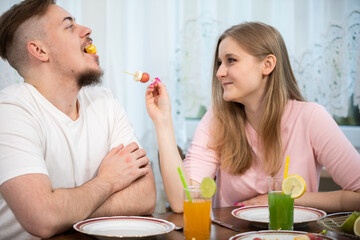 Obraz na płótnie Canvas Amused young couple spending time having breakfast.
