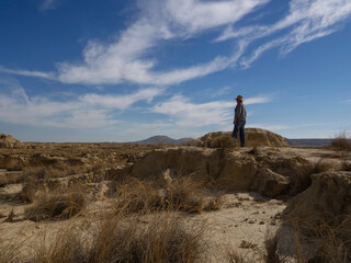 Man with hat in the desert looking at infinity. Bardenas Reales, Navarra, Spain.