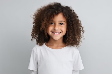 Portrait of a cute little african american girl with curly hair, isolated on grey background