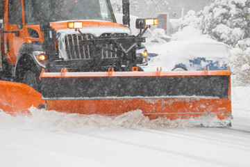 close up on snowplow driving on residential street