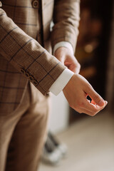 The image shows a man wearing a suit and tie. He is indoors and appears to be holding his hands. 5288