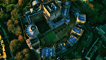 Aerial view of a historic Lancaster castle at sunset with surrounding greenery.