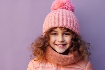Portrait of a cute little girl in a pink hat and scarf