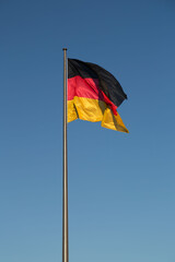 German flag on a flagpole against the blue sky
