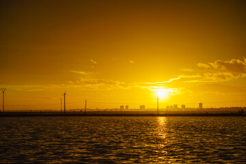 Sunset over sea and urban coastline