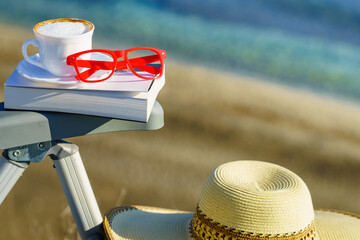 Coffee cup and book on sea coast