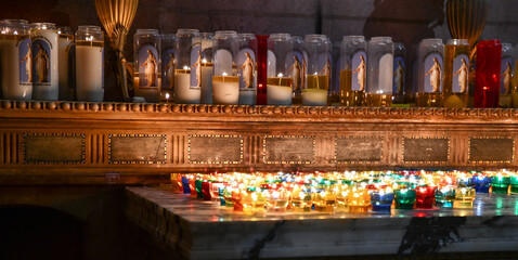 rows of prayer candles burning in the church cathedral