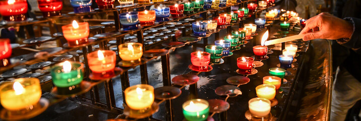 rows of prayer candles burning in the church cathedral