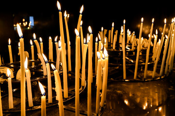 rows of prayer candles burning in the church cathedral