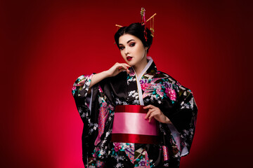 Photo of lovely lady dressed traditional floral print flowers black kimono isolated on red gradient...