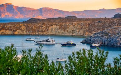 Expensive yachts are moored in the bay.