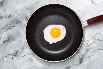 Tasty fried egg on pan on the desk