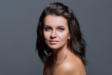 Naklejka premium Headshot portrait of young woman with hairstyle makeup on gray background