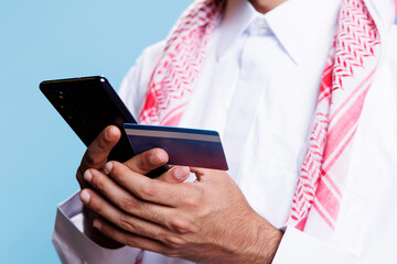 Arab man using digital banking service while paying for products on smartphone internet store....