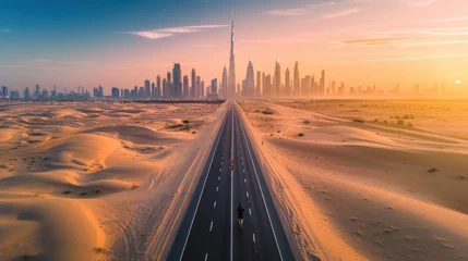 Schilderijen op glas View from above, stunning aerial view of an unidentified person walking on a deserted road covered by sand dunes with the Dubai Skyline in the background. Dubai, United Arab Emirates © Orxan