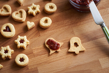 Filling Linzer Christmas cookies with strawberry jam