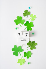 March 17 calendar and green clover leaves top view. St. Patrick's Day concept