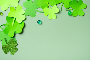 St. Patrick's Day minimalistic concept. Paper clover leaves on colored background with copy space