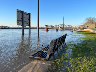 Panoramic view of flooded countenance boulevard of Zutphen with high water level of river IJssel and barrier fence under water at sunset.