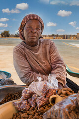african street vendor selling peanuts, old woman entrepreneur at an intersection