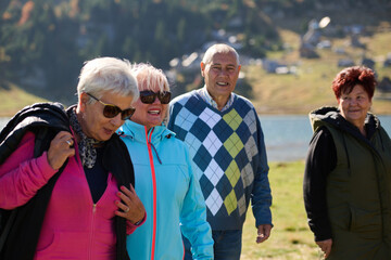 Fototapeta premium A family shares delightful moments with their friends amid the stunning landscapes of mountains, lakes, and winding paths, promoting a healthy lifestyle and the joy of familial bonds in the embrace of