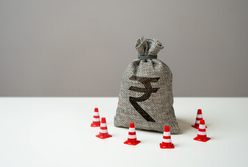 Indian rupee money bag blocked by road cones. Freezing of accounts and sanctions on capital....