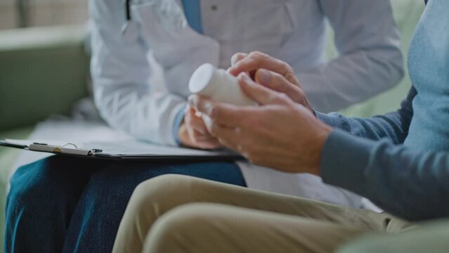 Closeup shot of older senior male patient hands holding pills discussing medical heath data form