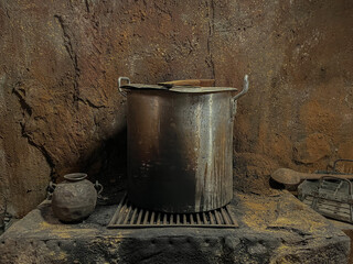 rustic stone stove with pot and wooden spoon