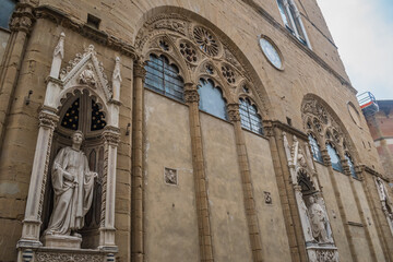 Orsanmichele church with architectural niches with saints on the facade and gothic window, Florence ITALY