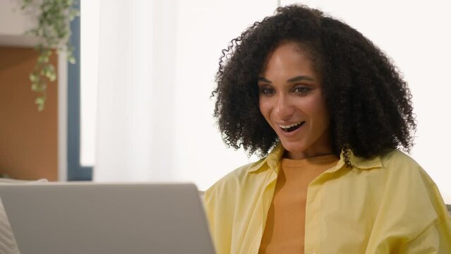 African American shocked ethnic woman freelancer businesswoman using computer happy emotion wonder shock winning online lottery victory luck achievement excited girl read good news on laptop at home