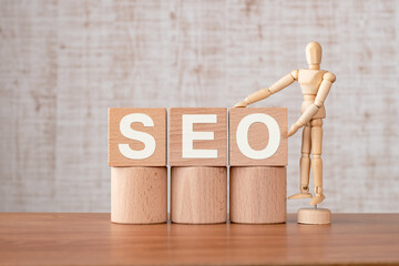 There is wood cube with the word SEO. It is an abbreviation for Search Engine Optimization as...