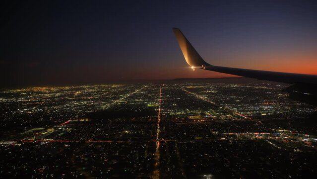 Jet plane prepare to landing in Los Angeles LAX airport. Porthole view with wing. Slow motion