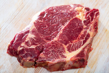 Obraz premium Image of raw cow chop on natural wooden surface, before cooking