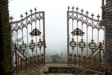 A metal gate opens up into the clouds at the Pura Pasar Agung Sebudi temple on the mountain after...