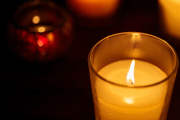 Close-up of Burning Candle in Glass on Black Background, Copy Space