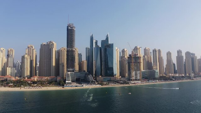 Aerial panoramic summer view of Dubai Marina skyline skyscrapers, boats and jet skis at JBR beach