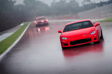 um carro vermelho em um autodromo em alta velocidade