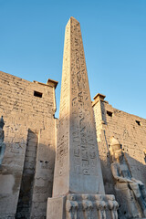 Seated statue of Ramesses II by the First pylon of the Luxor Temple, Egypt. Columns and statues of...