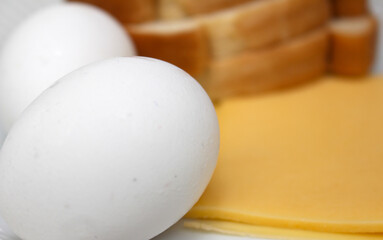 ingredients to make egg sandwich. egg with cheese and bread. food details. eggs with selective...