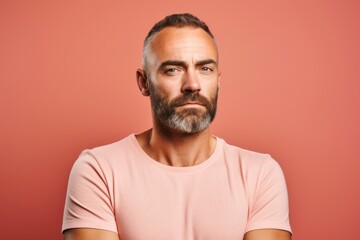 Portrait of a handsome mature man on a pink background. Men's beauty, fashion.
